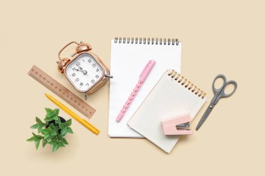 Renk arkaplan üzerinde farklı kırtasiye, bitki ve alarm saatine sahip kompozisyon