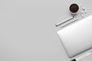 Modern cihazlarla kompozisyon, bir fincan kahve ve gri arka planda işaretler.