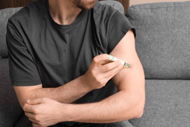 Şeker hastası adam evde tükenmez kalem kullanıyor, yakın plan.