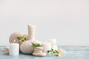 Renk tablosunda ışık arkaplanına karşı spa aksesuarları, kozmetik ürünleri ve çiçeklerle kompozisyon