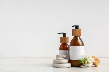 Hafif arkaplanda kozmetik ürünleri, spa taşları ve çiçek içeren kompozisyon