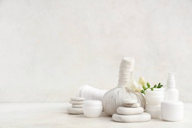 Farklı kozmetik ürünleri, spa aksesuarları ve hafif arkaplanda frezya çiçeği