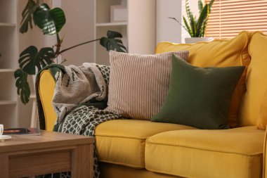 Odasında yastıklar olan rahat sarı kanepe, yakın çekim.