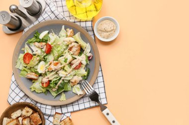 Lezzetli tavuklu Sezar salatası ve turuncu arka planda bir kase kızarmış ekmek.