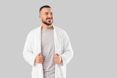 Gri arka planda, bornozlu genç yakışıklı adam.