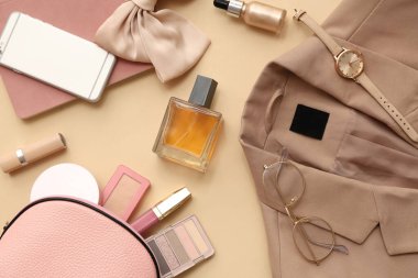 Renkli arka planda dekoratif kozmetik, aksesuarlar, kıyafetler ve cep telefonuyla kompozisyon