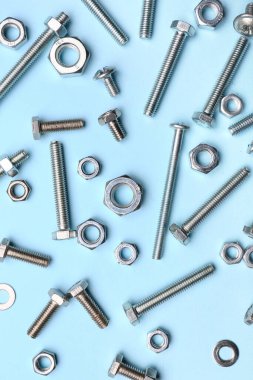 Mavi arka planda bir sürü cıvata ve krom fındık
