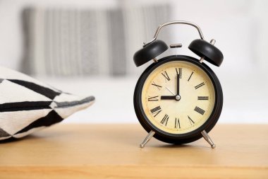 Yatak odasındaki bankta çalar saat, yakın plan.