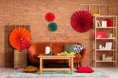 Çin Yeni Yıl kutlamaları için kırmızı kanepe, masa ve dekorla oturma odasının içinde.