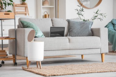 Oturma odasındaki kanepenin yanındaki çöp kutusunu aç.