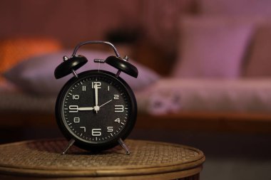Gece yatak odasındaki masada çalar saat, yakın plan.