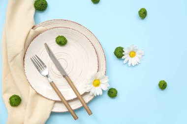 Mavi arka planda güzel çiçekli şık masa ayarları