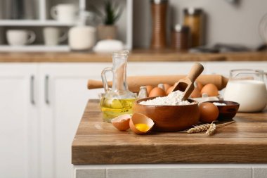 Mutfak tezgahında hamur hazırlamak için bir kase un, kepçe süt ve yağ.