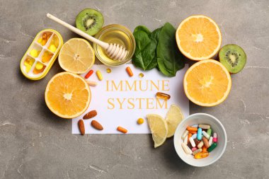 IMMUNE SİSTEM metin kompozisyonu, farklı haplar ve grunge arka planda sağlıklı yiyecekler