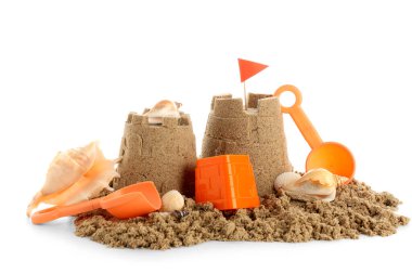 Beyaz arka planda kumdan, plaj oyuncaklarından ve deniz kabuklarından kale