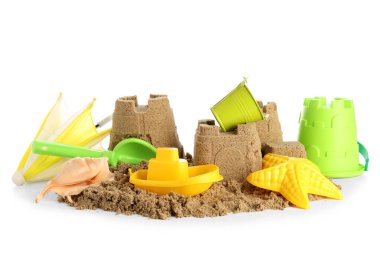 Beyaz arka planda kumdan kale, plaj oyuncakları ve küçük şemsiye