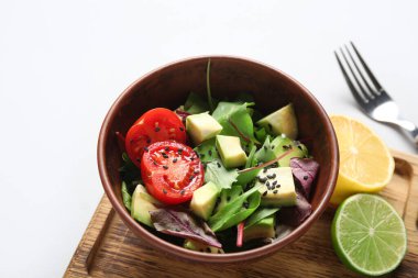 Çeri domatesli avokado salatası ve gri arka planda narenciye.