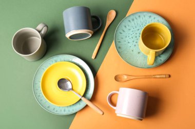 Renk arkaplan üzerinde kupalar, plakalar ve kaşıklar ile kompozisyon