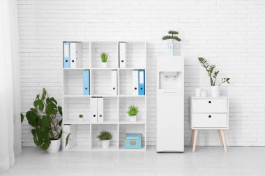 Modern su soğutucusu ve raf ünitesi olan hafif bir ofis.