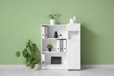 Modern su soğutucusu, ev bitkileri ve raf ünitesi olan şık bir ofis.