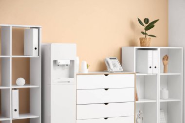 Modern su soğutucusu ve raf ünitesi olan şık bir ofis.