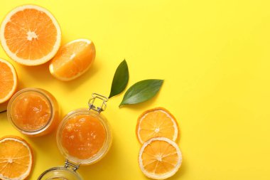 Sarı arka planda lezzetli turuncu reçel kavanozları