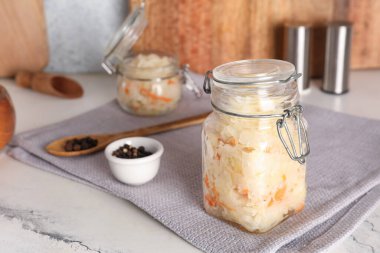 Kavanozda lahana turşusu ve biberler masada. Yakın çekim.