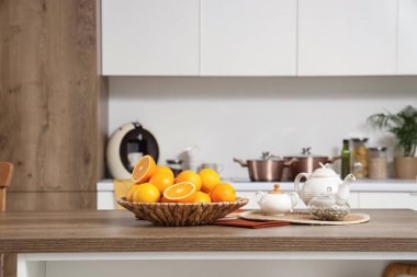 Mutfaktaki masada portakal ve çay ile hasır tabakta.