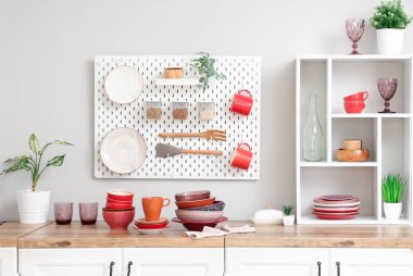 Tabaklar ve kaseler mutfaktaki beyaz duvarın yanında.