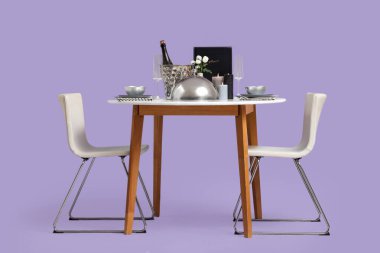 Şarap, saat ve leylak arkaplanda yanan mumlarla dolu iki kişilik restoran masası.