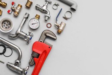 Gri arkaplanda tesisatçı eşyaları var.