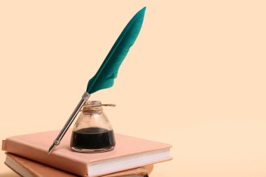 Bej arka planda uçlu kalem ve mürekkep hokkası olan kitaplar