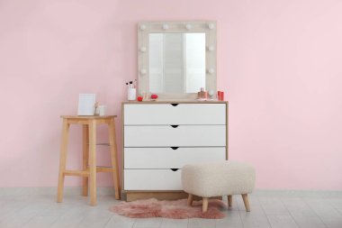 Aynalı, çekmeceli ve kozmetik ürünleri satan şık bir makyaj odası.