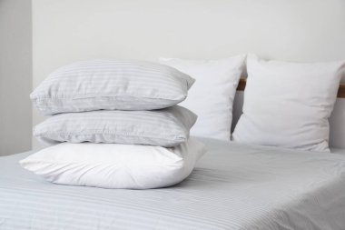 Gri battaniyeli rahat yatak ve şık yatak odasında yumuşak yastıklar, yakın çekim.