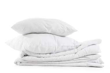 Beyaz arka planda izole edilmiş yumuşak yastık ve battaniye yığını