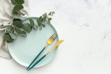 Beyaz grunge arka planında okaliptüs dalları olan güzel bir masa. Üst görünüm