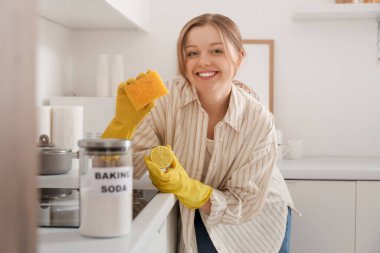 Mutfakta kabartma tozu ve limon temizleme sobasıyla genç bir kadın.