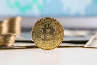 Bilgisayarın yanındaki ekranda grafikli altın bitsikkeler