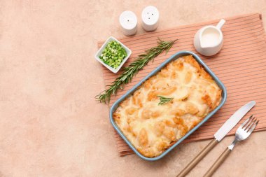 Lezzetli makarna, biberiye ve bej rengi grunge arkaplanda yeşil soğan ile pişirme yemeği.