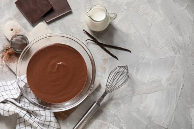 Gri arka planda lezzetli erimiş çikolatalı kase. Üst görünüm