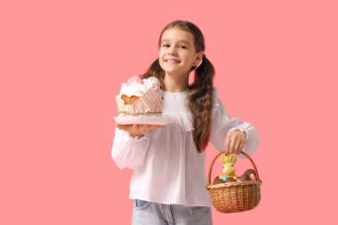 Paskalya pastası ve pembe arka planda hasır sepeti olan tatlı küçük bir kız.