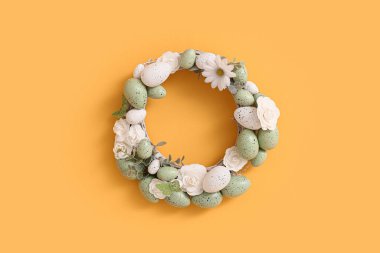 Sarı duvarda yumurtaları olan Paskalya çelengi