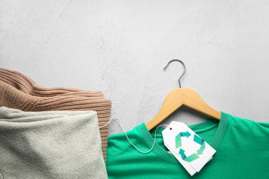 Gri arkaplanda geri dönüşüm logosu olan giysiler