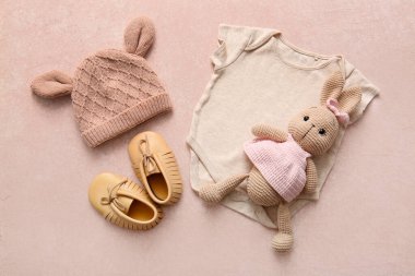 Bebek kıyafetleri, popolar ve arka planda oyuncak tavşan.
