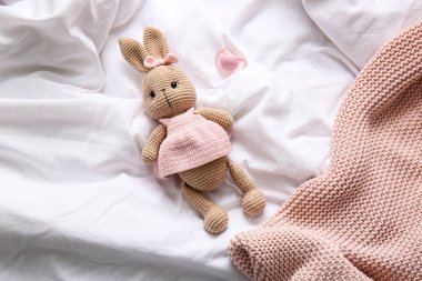 Oyuncak tavşan, emzik ve ekose kumaş.