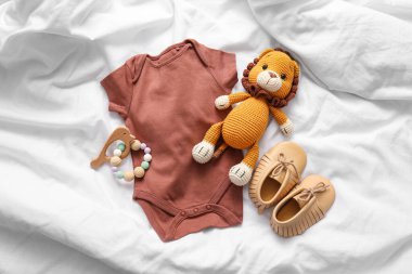 Beden giysisi, patik ve hafif arka planda oyuncaklar.