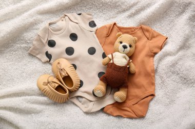 Şık bebek kıyafetleri, açık renk kumaşlı oyuncak ayılar.