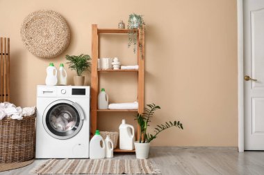 Modern çamaşır makinesi, raf ünitesi ve deterjan şişeleriyle şık bir çamaşır odası.