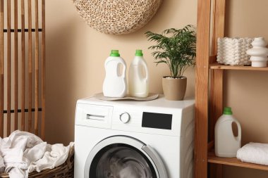 Şık çamaşır odasında deterjan şişeleri olan modern çamaşır makinesi.