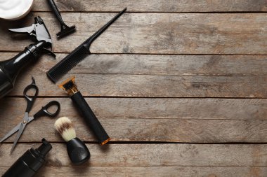 Ahşap arka planda modern budayıcı ile erkek traş aksesuarları